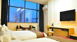 a hotel room with two beds and a desk and a window at Thank Hotel Jiangxi Jiujiang Lianxi District Railway Station Square in Jiujiang +47 photos