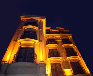 トラブゾンにあるGrand Vuslatの夜の黄色い灯りをつけた高層ビル