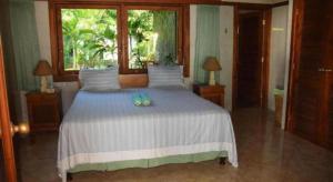 ein Schlafzimmer mit einem großen weißen Bett mit einem Fenster in der Unterkunft Tulamben Wreck Divers Resort & Restaurant in Tulamben + 121 Fotos