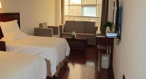 a hotel room with two beds and a desk at GreenTree Inn Rizhao Yantai Road in Rizhao