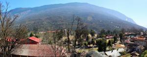 a mountain in the distance with a town and a city at Hotel Aroma Classic in Kulu