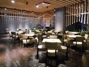 a restaurant with tables and chairs in a room at The Art Hotel in Shenzhen