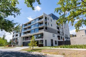 ein Apartmenthaus in einer Straße mit Bäumen in der Unterkunft Bright Lyneham Hideaway, Gym, Free Parking, ANU in Downer