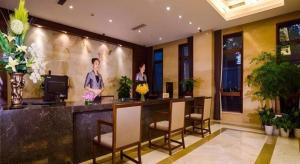 two people standing at a bar in a hotel lobby at Hangzhou Xixi Nade Runzeyuan Hotel in Hangzhou