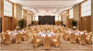 a large room with tables and chairs and a projection screen at Dusit D2 Binhu Changzhou Hotel in Changzhou