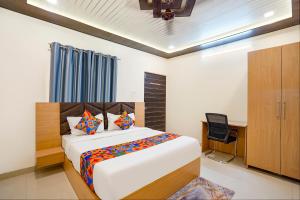 Un dormitorio con una cama, un escritorio y una silla. en FabHotel Paramhans Guest House - Sant Ravidas Ghat, en Varanasi