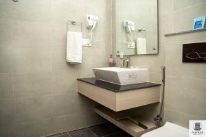 un baño con lavabo y espejo en Navaya Residence, en Pātan 31 fotos más