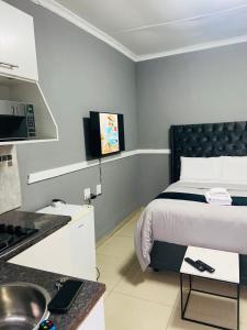 une chambre d'hôtel avec un lit et une cuisine dans l'établissement Gold Crown One Bedroom Self-Catering Apartment With NetFlix & YouTube, à Johannesbourg