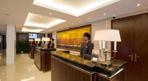 saguão de hotel com um homem de terno em um balcão em Jinjiang Metropolo Shanghai Minhang em Xangai