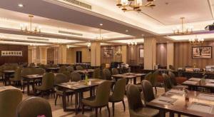 um restaurante com mesas e cadeiras em uma sala em Jinjiang Metropolo Shanghai Minhang em Xangai