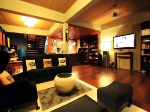 ein Wohnzimmer mit Sofa und Fernseher in der Unterkunft The Royal Chiangkhan Boutique Hotel in Chiang Khan