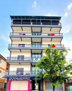 a tall building with balconies and a tree at Royal Agate Beach Resort in Pantai Cenang