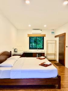 een slaapkamer met een groot bed en een raam bij Serenia Garden Resort in Ko Lanta Yai