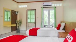 ein Schlafzimmer mit einem großen Bett mit rot-weißer Bettwäsche in der Unterkunft OYO 742 View Pruksa Resort in Ban Hin Chang (2)