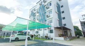 a white car parked in front of a building at Orchid Residence in Nakhon Si Thammarat