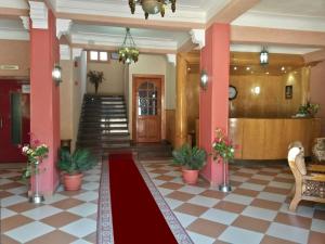 un hall avec piliers rouges et tapis rouge dans l'établissement Adriatica Hotel Marsa Matrouh, à Marsa Matruh
