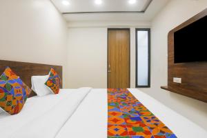 Un dormitorio con una cama con un televisor en la pared. en Hotel kingdom, en Indore 17 fotos más