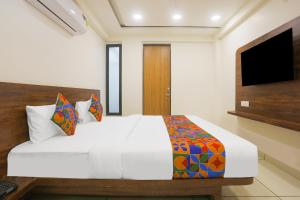 1 dormitorio con 1 cama blanca grande y TV en Hotel kingdom, en Indore