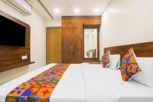 1 dormitorio con 1 cama blanca grande con una manta colorida en Hotel kingdom, en Indore
