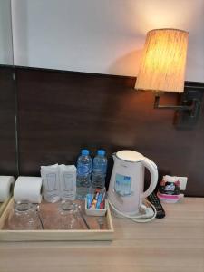 einem Tisch mit Wasserflaschen und einer Lampe darauf in der Unterkunft AtWhitePatong in Patong Beach