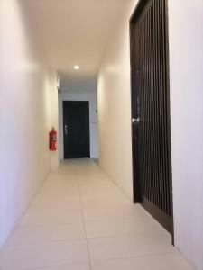 ein leerer Flur mit einer Tür und einem Feuerlöscher in der Unterkunft AtWhitePatong in Patong Beach