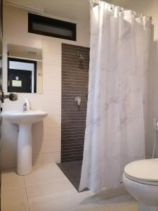 ein Badezimmer mit einem weißen Duschvorhang und einem Waschbecken in der Unterkunft AtWhitePatong in Patong Beach