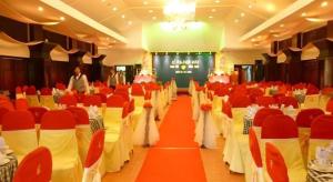 une salle de banquet avec des tables et des chaises blanches et rouges dans l'établissement Can Gio Resort, à Ấp Long An 135 autres photos
