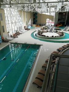 une grande piscine avec des chaises dans un bâtiment dans l'établissement Uniri Urban Escape 103, à Craiova