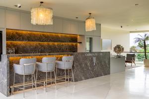 een bar in een lobby met stoelen en een toonbank bij Sore Escape Tumbak Bayuh by Betterplace in Tumbak Bayuh