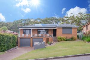 a brick house with a garage in a yard at Coastal Family Oasis with Pool, Outdoor Kitchen, Kids Play Area in Belmont