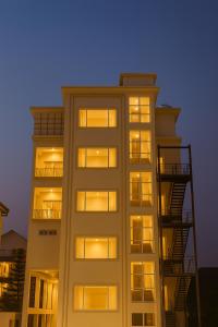 un edificio alto y blanco con ventanas y escaleras de incendios en Xenious Opulent Hamirpur, en Hamīrpur