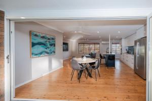 a dining room and kitchen with a table and chairs at Coastal Family Oasis with Pool, Outdoor Kitchen, Kids Play Area in Belmont