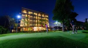 zwei Männer, die vor einem Gebäude Golf spielen in der Unterkunft Mira Residence & Resort (halal) in Chiang Mai
