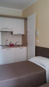 a bedroom with a bed with a sink and white cabinets at Hotel Tommaseo in Genoa