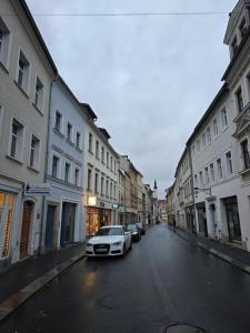 ein Auto, das auf einer Straße mit Gebäuden parkt in der Unterkunft FERIENWOHNUNG 75m2 APARTMENT in ZITTAUER STADTZENTRUM INNENSTADT INNENRING TOP LAGE - WOHNEN AUF ZEIT IN ZITTAU - 3 RAUM WOHNUNG in Zittau
