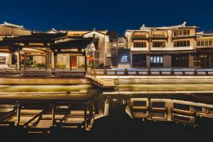 ein Gebäude neben einem Wasserkörper in der Unterkunft Atour S Hotel Wuxi Nanchang Street in Wuxi