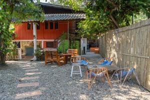 Un patio con sillas y una mesa y una valla. en Easy house, en Pai