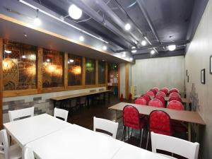 a dining room with white tables and red chairs at Hotel Casa Suwon in Seryu-dong
