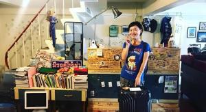 a woman standing in a store talking on a cell phone at Oldie and Sleepy Hostel in Udon Thani
