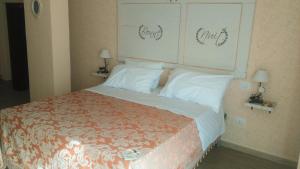 una camera da letto con un grande letto con cuscini bianchi di Nonna Carò a Fermo