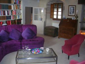 a living room with a purple couch and a coffee table at Logis de la Filanderie in Bécherel