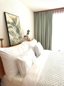 a bedroom with a bed with white pillows and a window at Studio meublé in Saillon