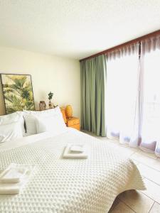 a bedroom with a large white bed with a window at Studio meublé in Saillon
