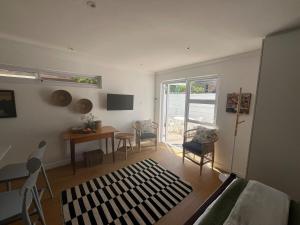 een woonkamer met een bank, een tafel en stoelen bij The Sultan Cottage in Stellenbosch