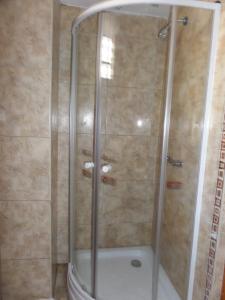 a shower with a glass door in a bathroom at Pirwa Backpackers Colonial in Cusco
