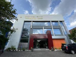 ein Gebäude mit einem davor geparkten Auto in der Unterkunft Kharisma Hotel in Madiun