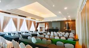 a large auditorium with white chairs in a room at HW Hotel Padang in Kampungdurian +178 photos