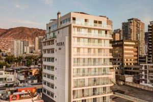 un grand bâtiment blanc dans une ville avec des bâtiments dans l'établissement Wyndham Garden Antofagasta Pettra, à Antofagasta 100 autres photos