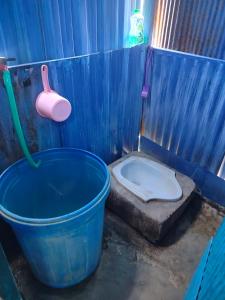 a blue bathroom with a bucket and a toilet at Atta Ratu Homestay komodo in Komodo