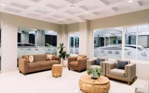 ein Wohnzimmer mit Sofas, Stühlen und einem Tisch in der Unterkunft HOTEL GRAND KUTILANG SYARIAH in Lampung